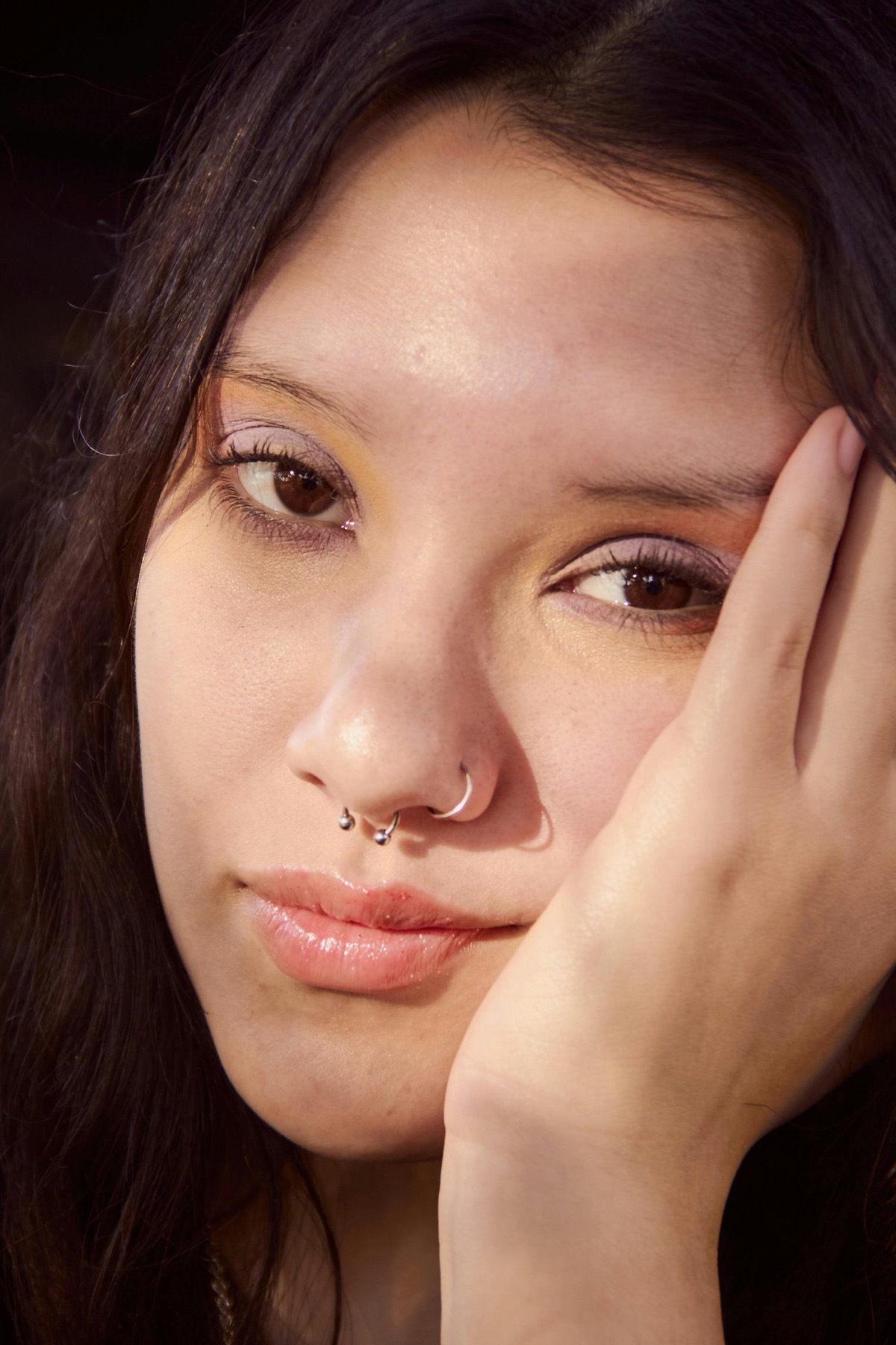 Warm portrait with a septum ring and nostril hoop